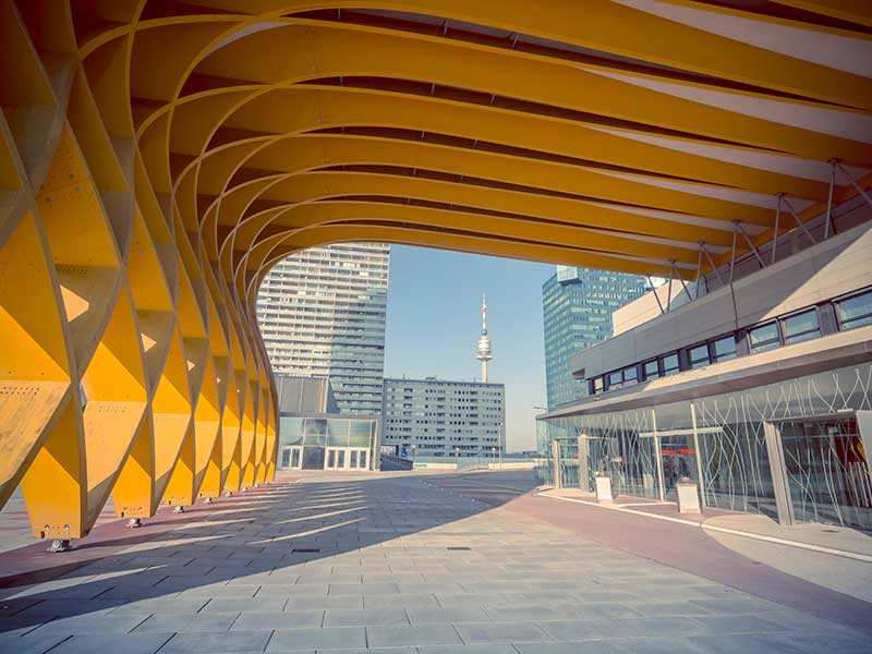 Der Eingang des Austria Center Vienna (ACV) und im Hintergrund Wolkenkratzer an der Donau und der Donauturm