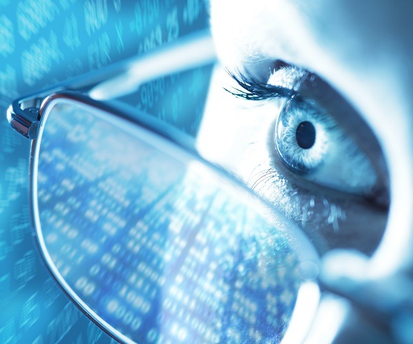 Nachaufnahme einer Frau bei der sich Daten in der Brille spiegeln