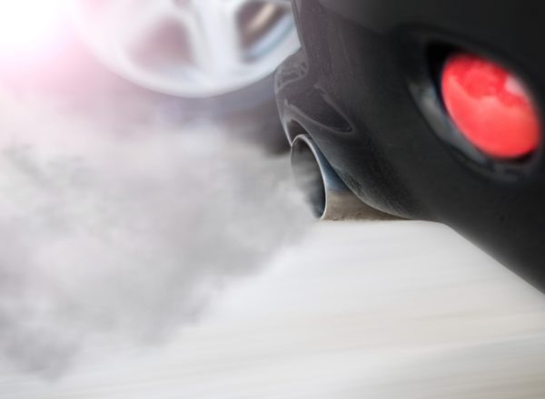 Qualm kommt aus dem Auspuff eines schwarzen Autos