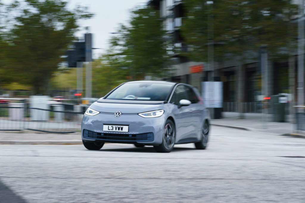 VW ID.3 fährt in der Stadt mit Gebäuden im Hintergrund