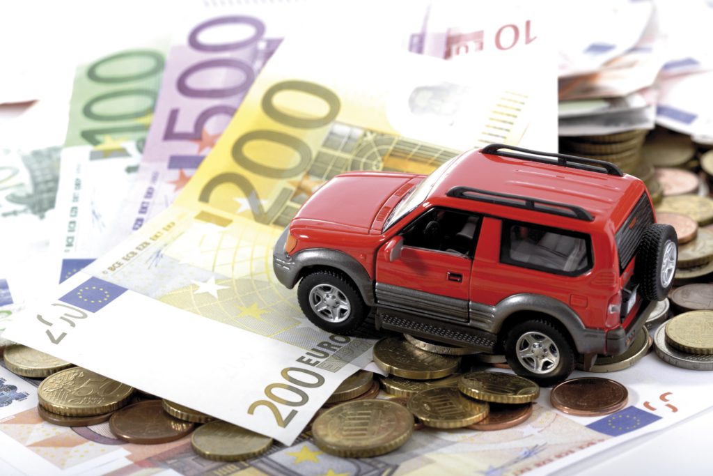 Spielzeugauto auf einem Stapel voller Geld