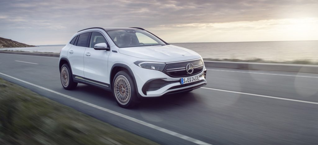 Elektrofahrzeug Mercedes-Benz EQA auf einer Straße mit Meer im Hintergrund